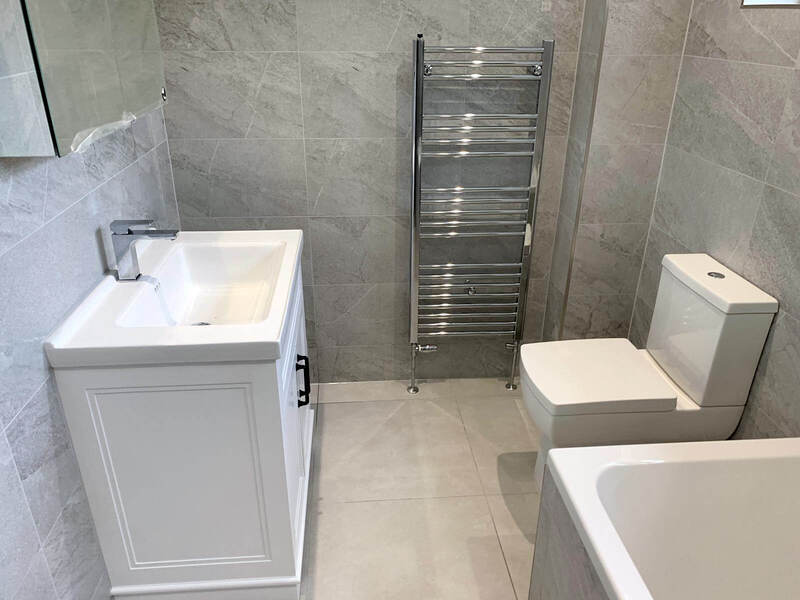 Modern bathroom with white vanity cabinet and grey floor tiles renovated by St Albans Bathroom Fitters