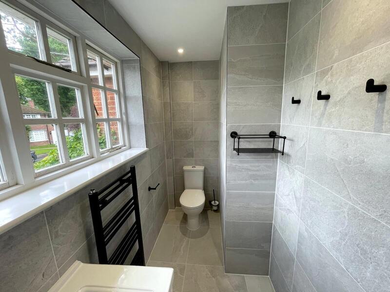 Modern bathroom in St Albans with grey tiles and large window