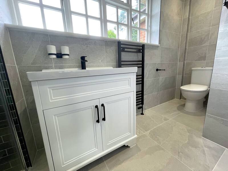 White vanity unit and grey tiled wall in renovated St Albans bathroom